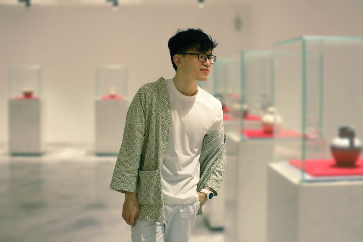 man in green and white long sleeve shirt and white pants standing