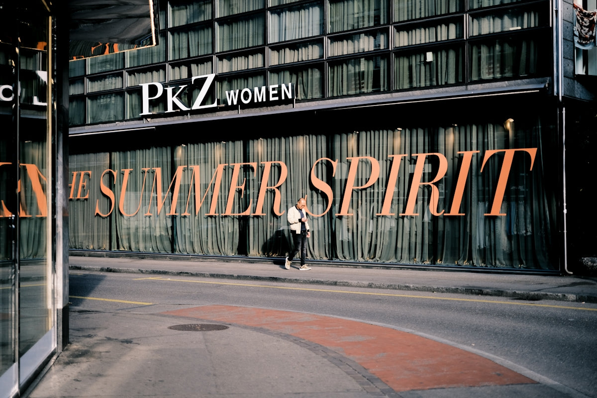 a woman walking down the street in front of a store