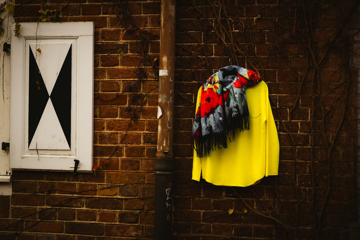 A yellow shirt hanging on a brick wall