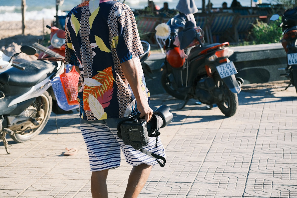 a man standing on a sidewalk holding a camera