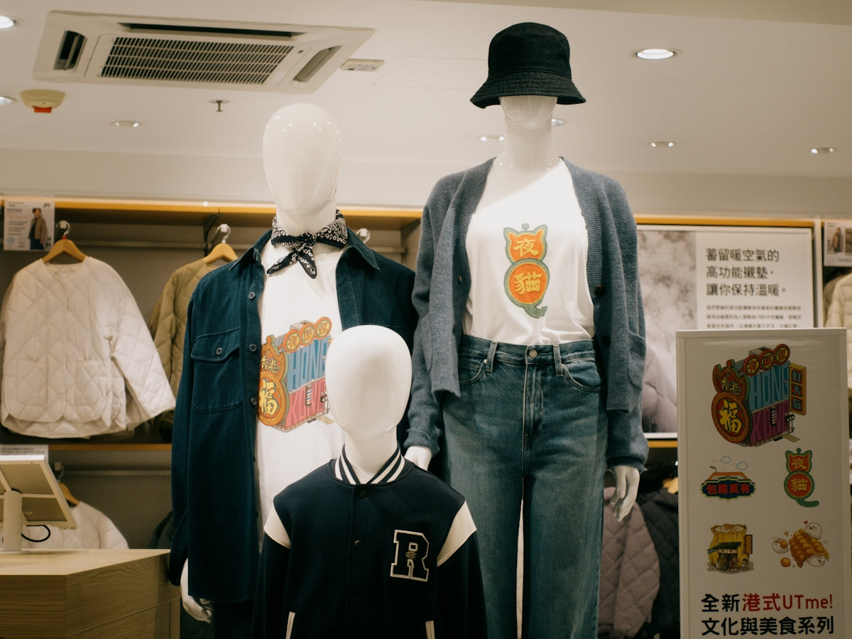 Two mannequins wearing shirts and hats in a store