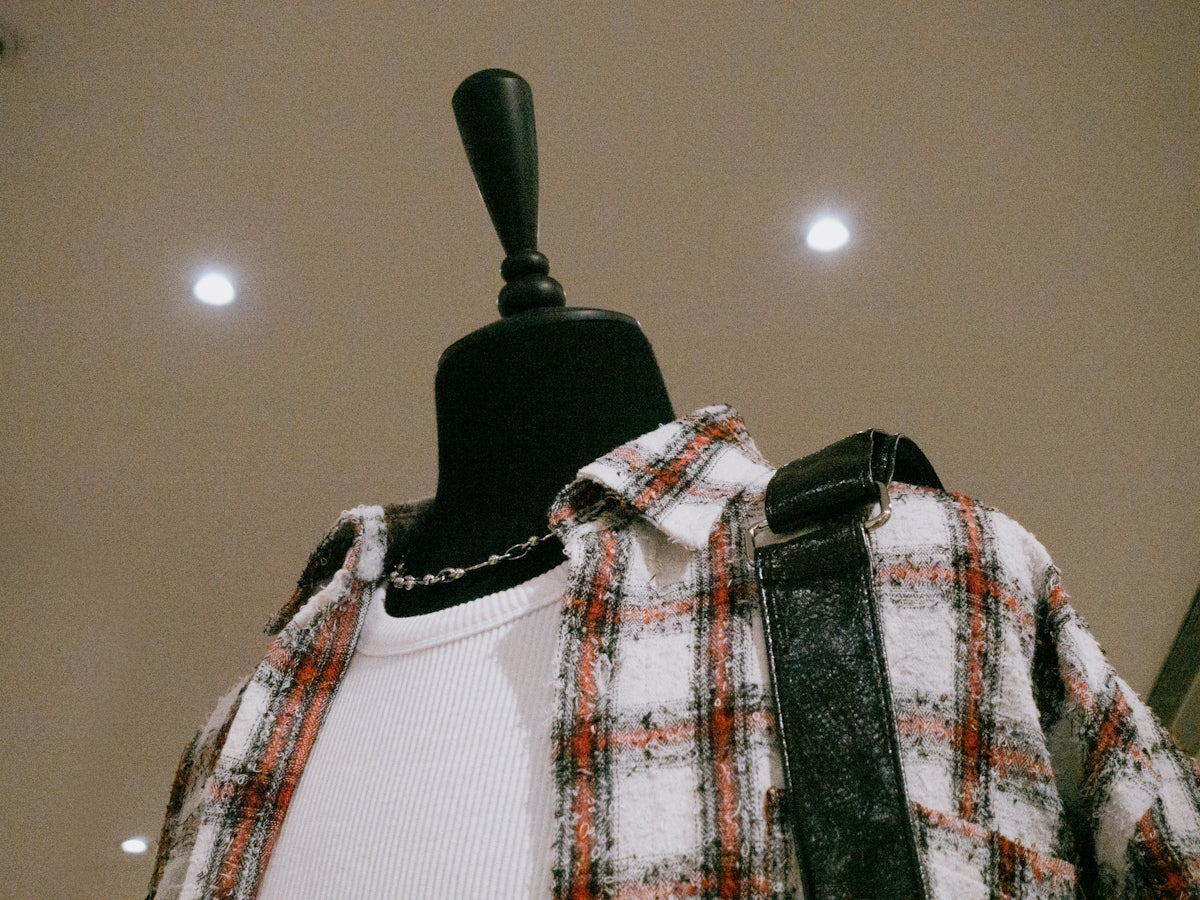 A mannequin wearing a plaid shirt and suspenders
